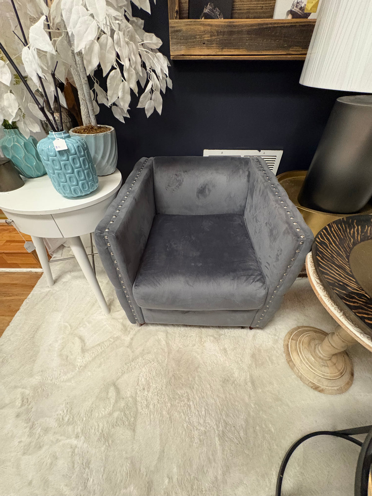 grey velvet tufted accent chair with nailhead trim and wooden feet.