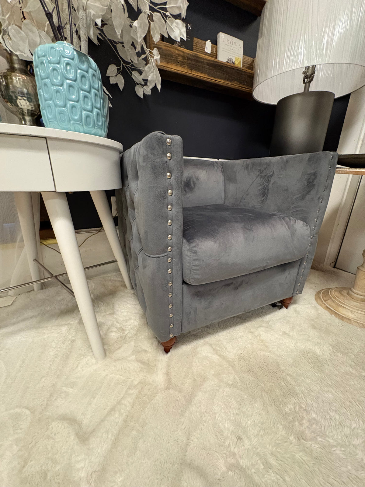 grey velvet tufted accent chair with nailhead trim and wooden feet.