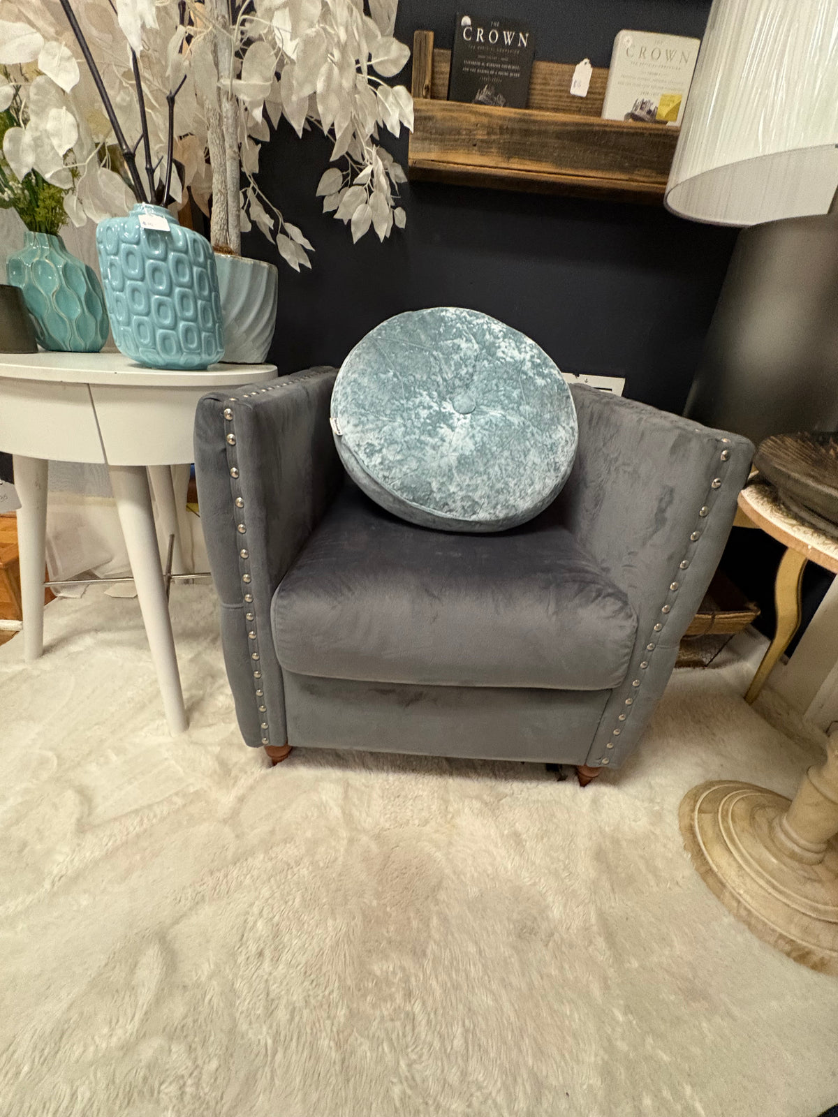 grey velvet tufted accent chair with nailhead trim and wooden feet.